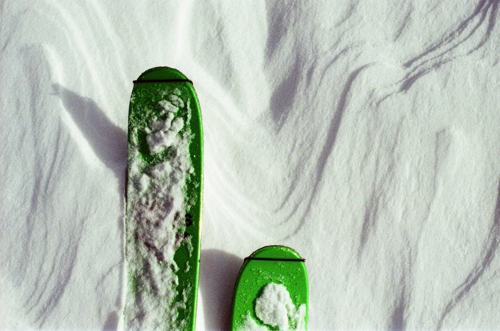 Top view of green contemporary skis covered with snow in cold weather in winter