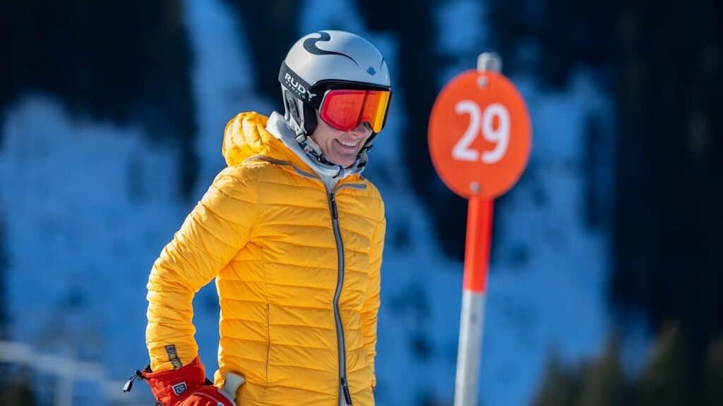 A Skier Wearing a Yellow Winter Jacket and ski goggles that are not fogged