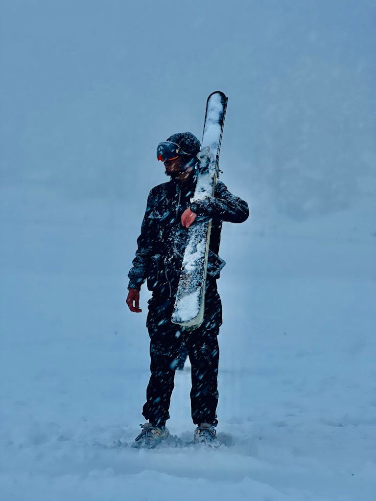 Man Holding Ski on Shoulder in Snow
