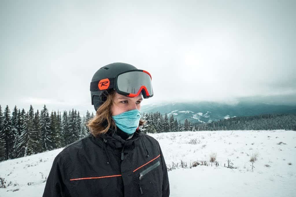 Woman in Black Jacket Wearing ski helmet and goggles on Snow Covered Ground